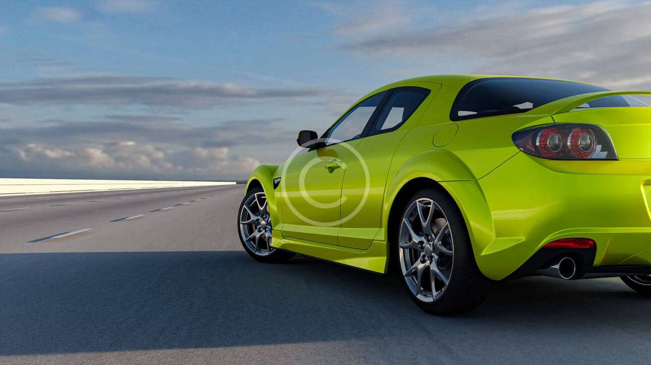 A bright green sports car driving on an open road under a cloudy sky.